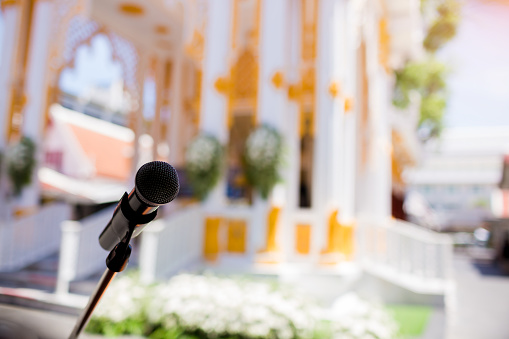 Microphone with blurry outdoor location for Buddhist activities. The concept of speaker.