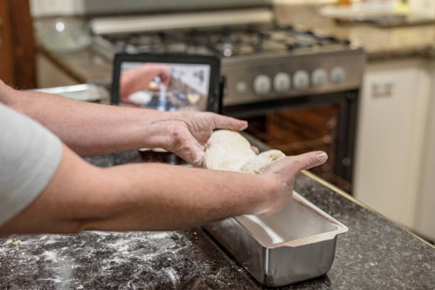Homemade - Learning how to make bread dough with the aid of video on the tablet