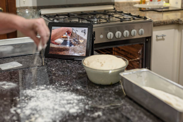 Homemade - Learning how to make bread dough with the aid of video on the tablet