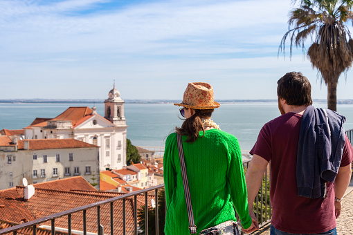 Lisbon, Portugal 8 March 2020: Couple looking at Lisbon skyline from view point.