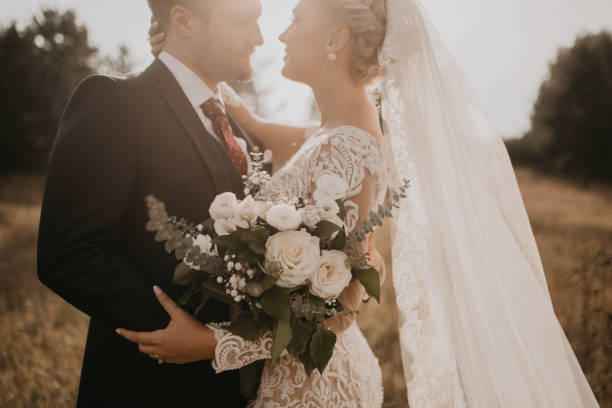 istock Very beautiful bride and groom having romantic time while wind blows wheats in the forest. 1248327134