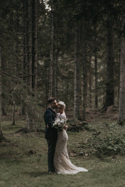 istock Very beautiful bride and groom having romantic time while wind blows wheats in the forest. 1248327307