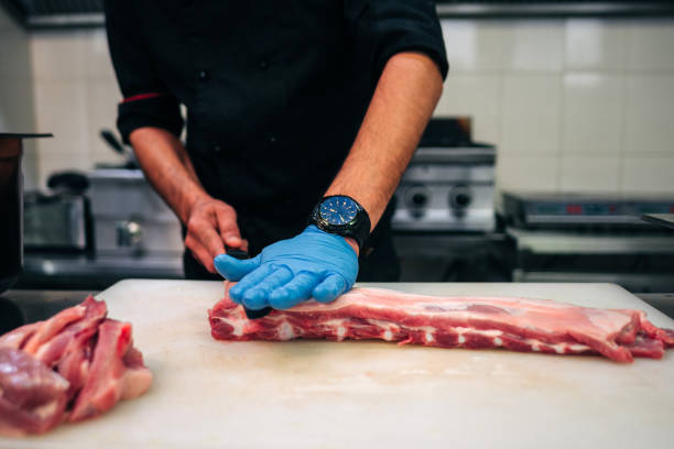 istock Male chef cutting raw pork ribs 1248327560