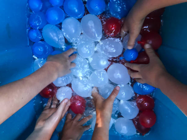 istock Children getting ready for a festive, summer water balloon fight. 1248328550