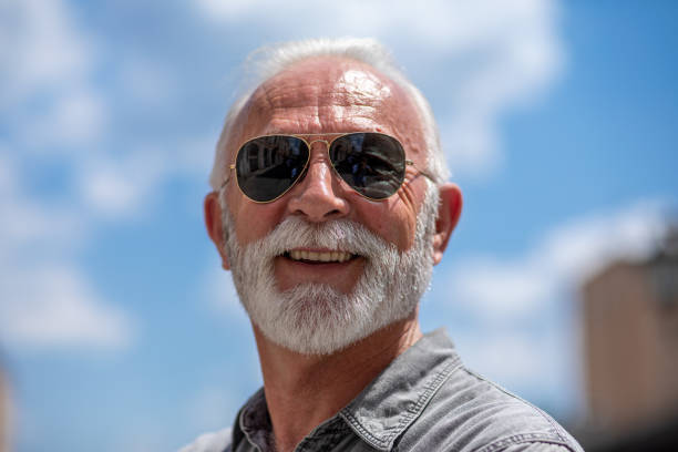 istock Old rich man with sun glasses and beard on street smiling 1248329529