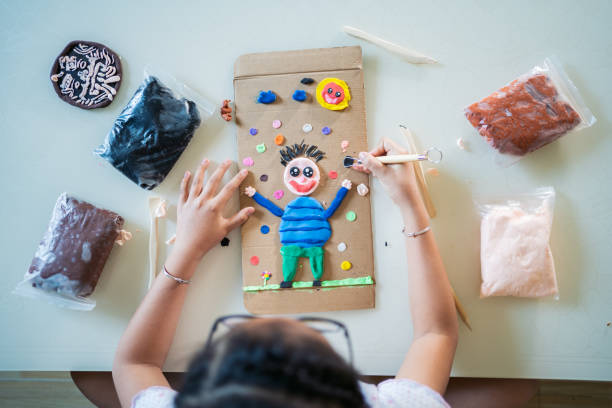 bambina che gioca con la plastilina a casa - shaping clay foto e immagini stock