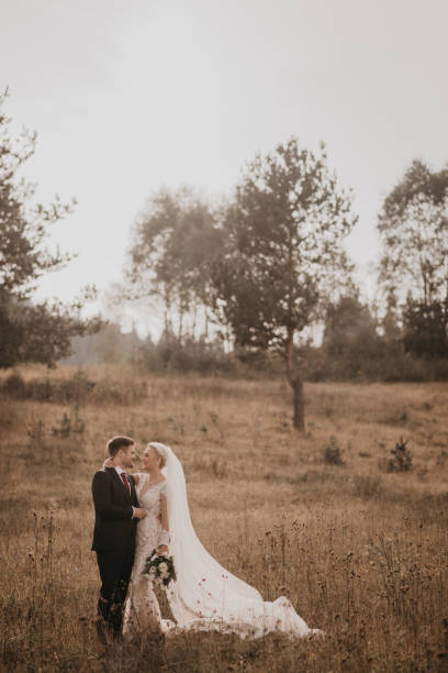 istock Very beautiful bride and groom having romantic time while wind blows wheats in the forest. 1248330750