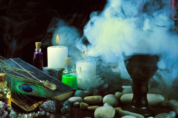 Magic potion, book, crystals, stones and candles with smoke Magic potion, ancient book, crystals, stones and candles with smoke on a black background. witch photos stock pictures, royalty-free photos & images