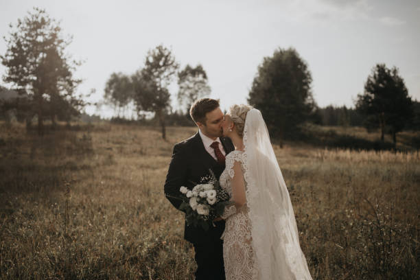 istock Very beautiful bride and groom having romantic time while wind blows wheats in the forest. 1248330830