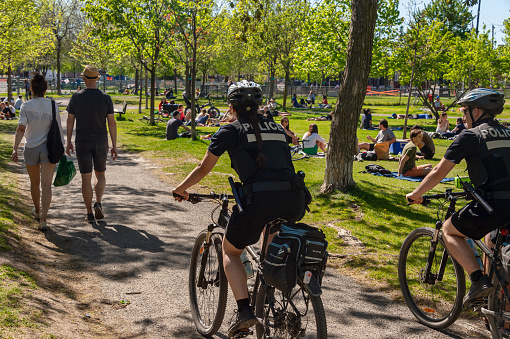 Montreal, Canada - 23 May 2020: Police patrol Laurier park to enforce the coronavirus physical-distancing laws