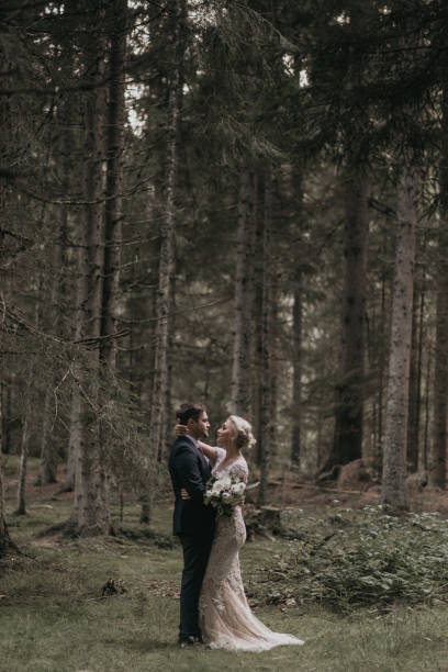 istock Very beautiful bride and groom having romantic time while wind blows wheats in the forest. 1248330863