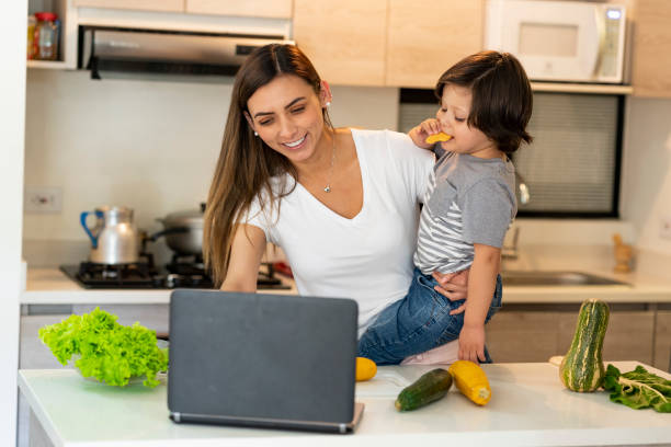 istock Latin ethnic woman accompanied by her son in the kitchen, while learning a recipe from youtube, during the Covid 19 1248332510
