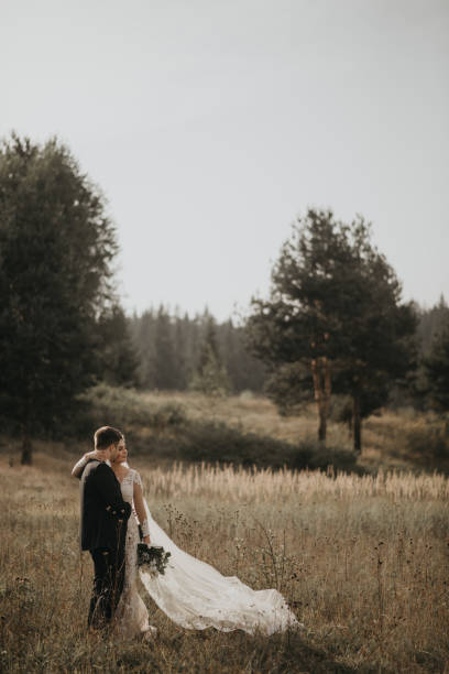 istock Very beautiful bride and groom having romantic time while wind blows wheats in the forest. 1248333274