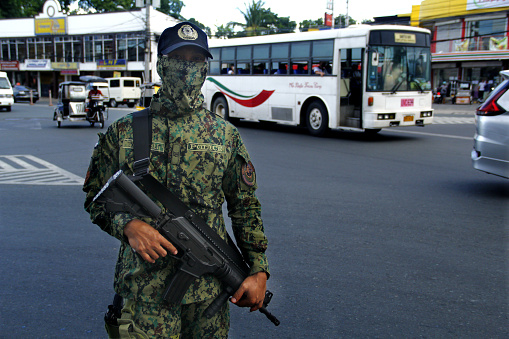 Antipolo City, Philippines - June 1, 2020: Weapon bearing soldier in uniform maintain order and peace in the streets.