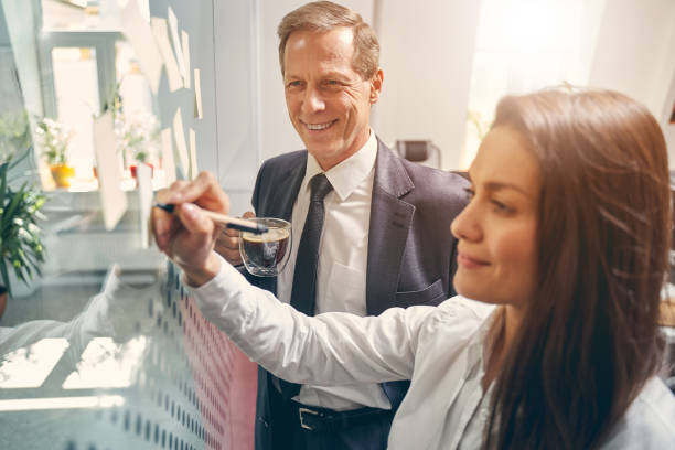 istock Two friendly colleagues standing near smart desk 1248377456