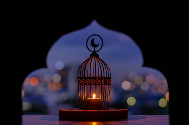 Lantern that have moon symbol on top with city bokeh light. Lantern that have moon symbol on top with city bokeh light and blurred focus of paper cut for mosque shape background. Islamic new year concept. muharram stock pictures, royalty-free photos & images