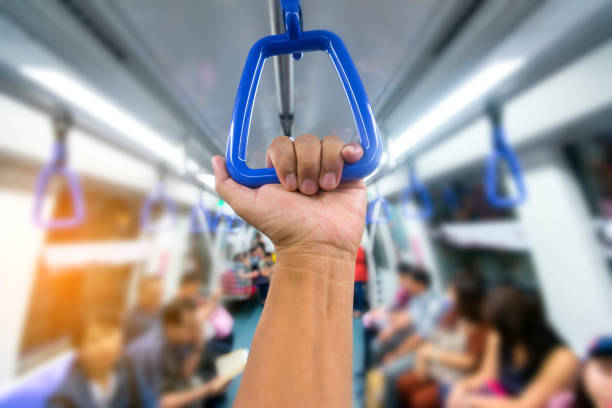 istock Passenger  hand holding onto a handle of a train on blur background. 1248384618