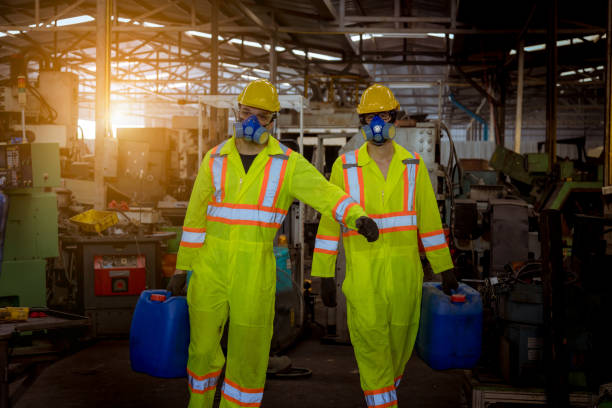 un'industria ingegnere che indossa uniforme di sicurezza, guanti neri e maschera antigas sotto controllo serbatoio chimico nel lavoro di fabbrica dell'industria - half tank foto e immagini stock