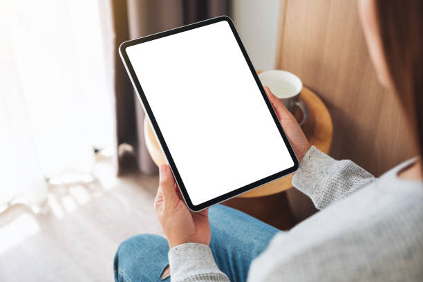 istock a woman holding black tablet pc with blank desktop white screen while sitting on a cozy white bed at home 1248391848
