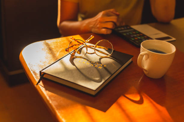 istock Woman checking smart phone with personal organizer diary with eyeglasses and coffee mug on table at home. 1248394552