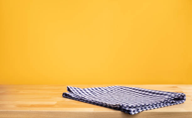 istock Blue fabric,cloth on wood table top on yellow wall background. 1248395225