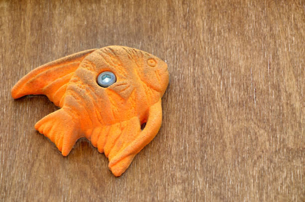 istock Orange fish toy on wooden background with copy space 1248399121