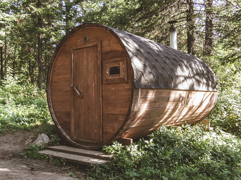 A personal sauna in the woods. Round wooden sauna in the forest. Barrel