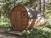 A personal sauna in the woods. Round wooden sauna in the forest. Barrel
