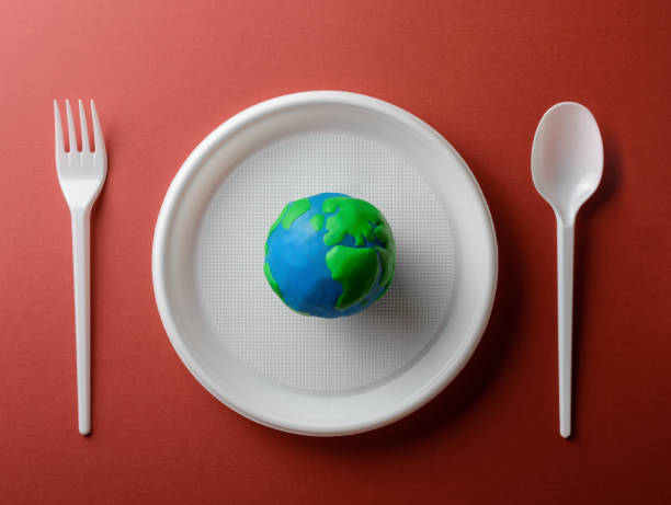 istock Serving table with Earth planet, plastic plate, spoon and fork. Ecology Concept for Earth Hour, Earth Day, Ocean Day and other ECO dates. 1248406198