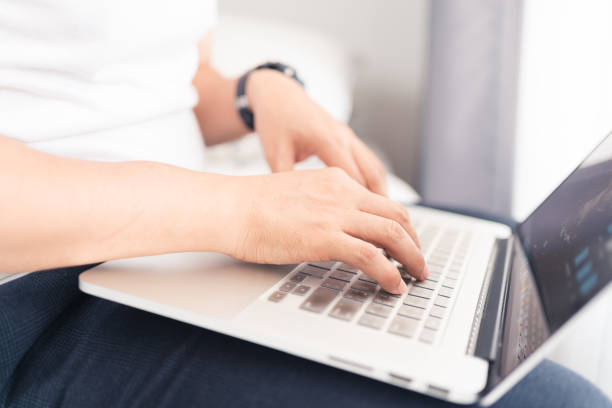istock Close up of Asian man hands using laptop computer working from home sitting on bed, digital lifestyle, work from home concept 1248406345