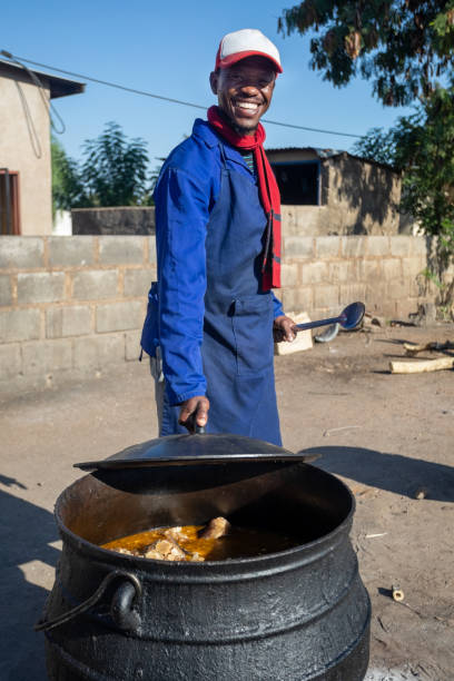człowiek gotowania tradycyjnych potraw botswana - dishing out zdjęcia i obrazy z banku zdjęć