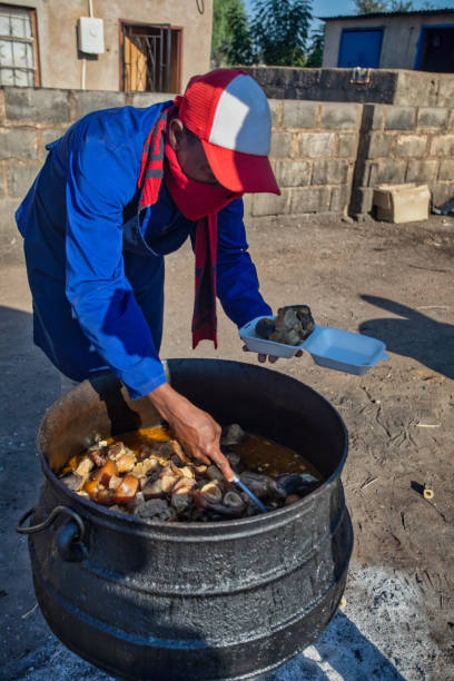 człowiek gotowania tradycyjnych potraw botswana - dishing out zdjęcia i obrazy z banku zdjęć