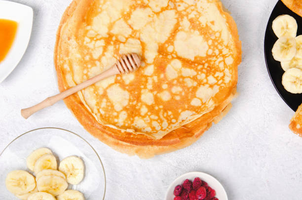 istock Pancakes with berries and honey for breakfast on white table 1248410118