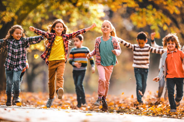istock Playful children having fun while running in autumn day at the park. 1248416931