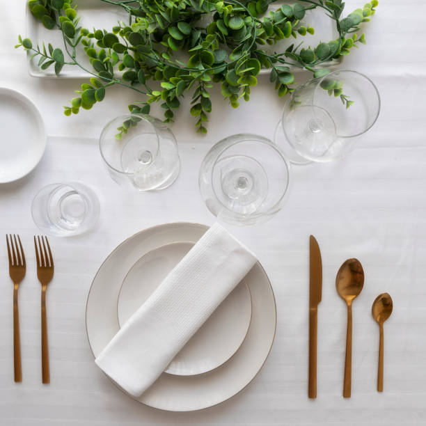 istock Elegant table setting with tableware and decorations for dinning.Top view of white porcelain plates, glasses, decorative textile and cutlery 1248418694