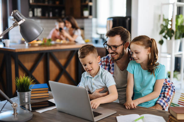 istock Kids having fun at home, playing with their father, using laptop 1248421540