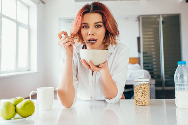 istock attractive girl eating cornflakes with milk for breakfast during quarantine 1248423916