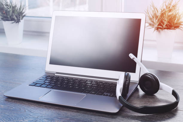 Laptop with headphones on white desk