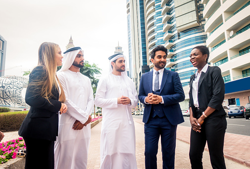 Multi-ethnic group of people on a business meeting in the UAE - Business people walking outdoors and talking about business