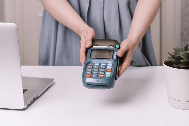 istock Female hands holding NFC payment terminal in a shop 1248426233