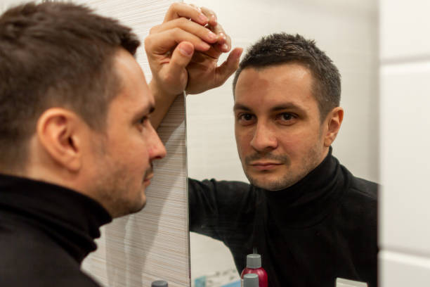 istock reflection of a young guy looking in a mirror. 1248426594