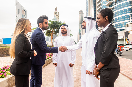 Multi-ethnic group of people on a business meeting in the UAE - Business people walking outdoors and talking about business