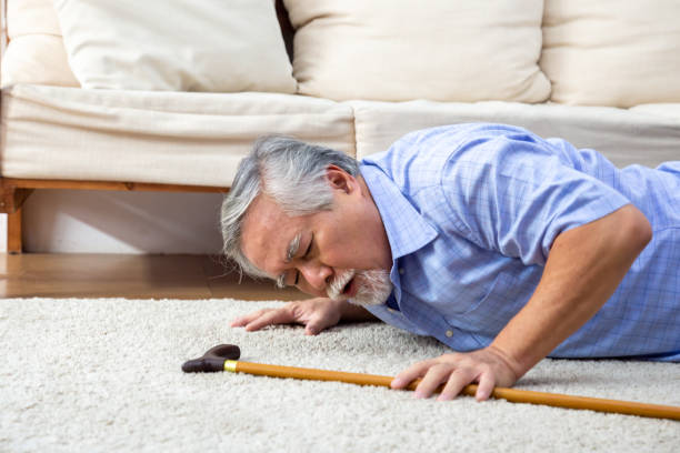 asiatische senior mann fällt auf teppich und liegt auf dem boden im wohnzimmer zu hause, fälle von älteren erwachsenen konzept - falling people tripping senior adult stock-fotos und bilder