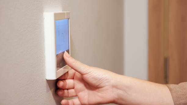 istock woman sets thermostat pressing keys in comfortable hotel 1248433398