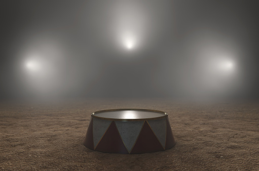 An empty circus ringmasters podium backlit by dramatic spot lights on a dark moody background - 3D render