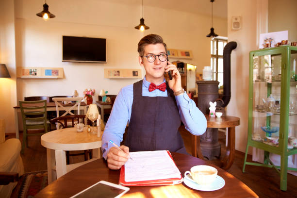 istock Small business owner young man working in his cafe 1248436365