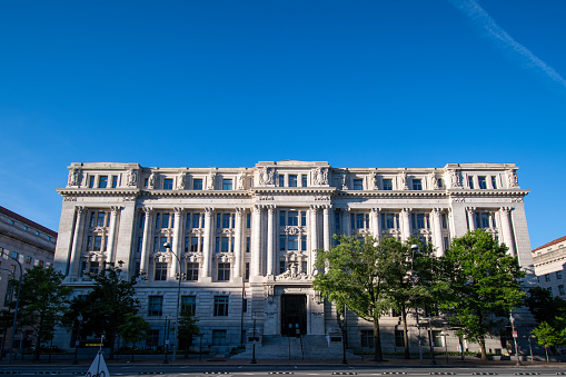 The Federal Department of Agriculture building in Washington DC on a clear blue sky day with Washington Monument in the background.