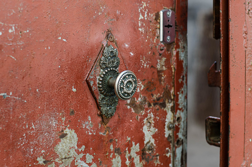 Vintage handle on the door. The old iron door. Metal gate. Cracked paint.