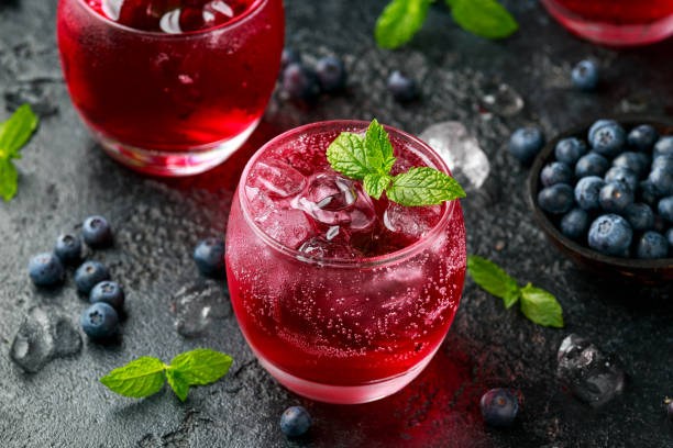 istock Refreshing Blueberry cocktail with ice and mint on rustic black table 1248440749