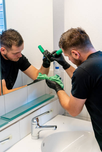 istock professional cleaner scraping dirt and spots from a bathroom mirror during a general spring cleaning of an apartment bathroom 1248441176